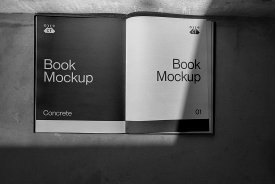 Elegant book mockup lying open on a concrete surface with shadow play, showcasing realistic textures and design presentation.